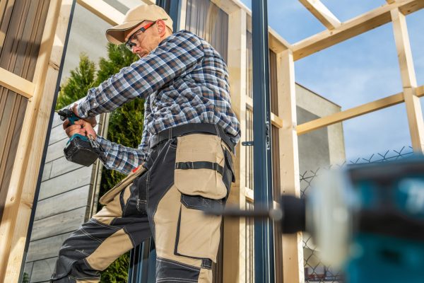 Construction Contractor Building Wood Frame and Composite Walls Made Garden Shed. General Construction Theme.